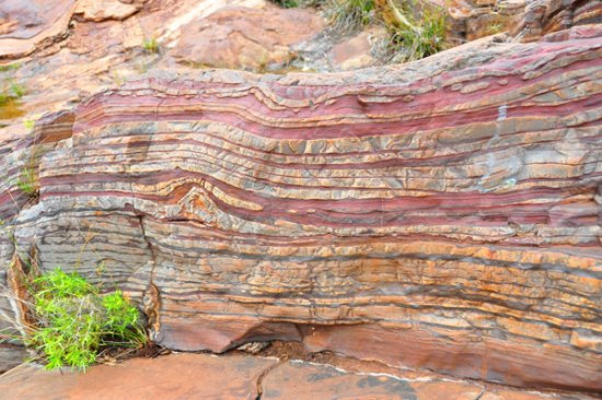 Banded iron formations Karijini National Park, Western Australia. The layers of reddish iron show the presence of oxygen, which bonded with the iron to form a rust-like iron oxide. These formations date most commonly from the period of 2.4 to 1.9 billion years ago, after the Great Oxidation Event. 